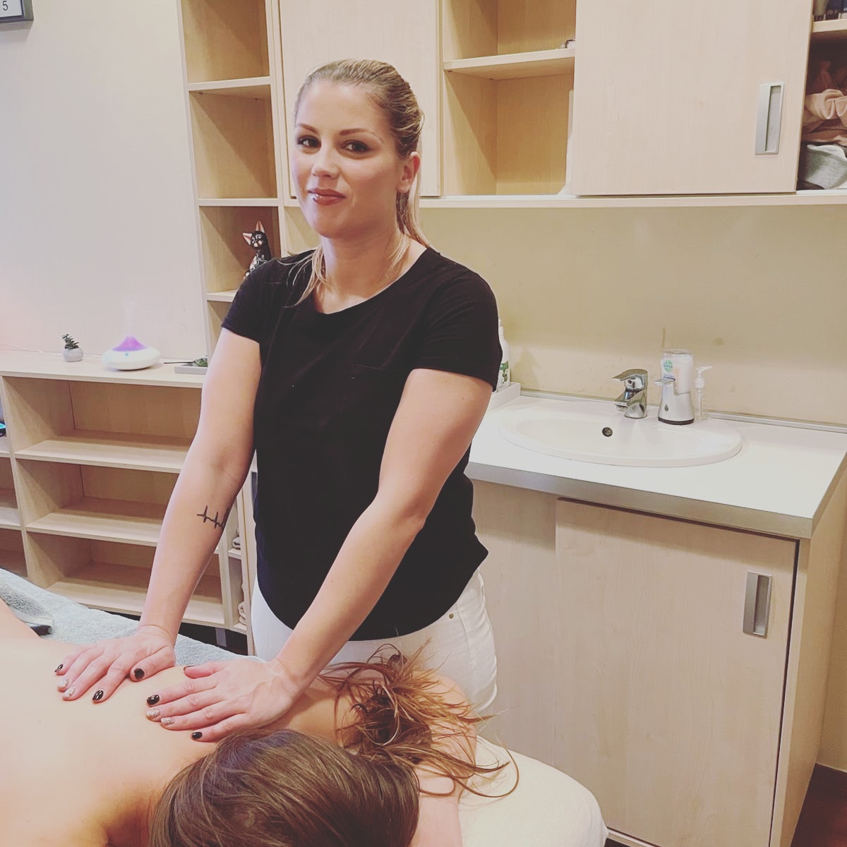 Fénykép Evelinről, ahogy a masszázsszalonban áll masszírozás közben.